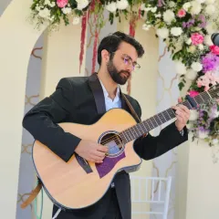 Playing the guitar at a beautiful wedding reception. The floral decor and elegant setting called for a mix of classic love songs and soft acoustic numbers.