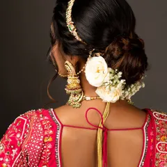 A shot from the back, highlighting the elegant hair jewelry (matha patti) and statement earrings that complete the bridal look.