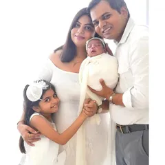 A timeless family portrait celebrating a new arrival. Dressed in classic white, this family's love shines through, creating an elegant and heartwarming image perfect for displaying in your home.