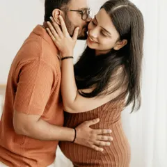 A sweet kiss on the cheek during a boho-themed couple's maternity session. We focus on capturing these small, affectionate gestures that tell your love story.