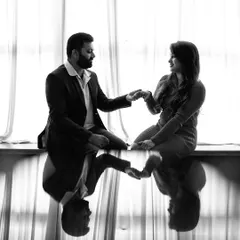 An artistic black and white photo using reflections to create a symmetric and timeless couple portrait.