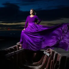 This dramatic shot on a boat at dusk shows the full potential of the purple gown's flowing satin skirt. It's an epic look for a creative pre-wedding photoshoot.