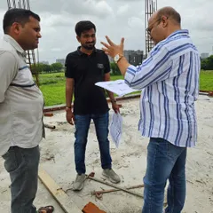 Discussing the architectural plans on-site with clients for their new property. Aligning the construction with Vastu principles early on is key to a harmonious space.