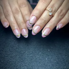 A modern and delicate French manicure. This look features a classic nude base with a fine, shimmering gold line tracing the tip of the nail. It's a subtle yet glamorous style that works beautifully for both daily wear and special events.