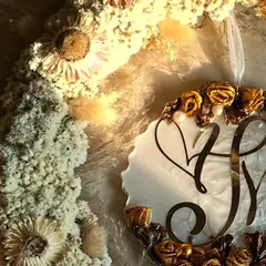 A close-up of the hanging logo wreath, showing the detail of the preserved flowers and the custom initial logo. It's a beautiful way to celebrate a new union.