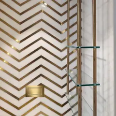 Details make the design. In this powder bathroom, I used a bold chevron pattern with inlaid brass in white marble to create a feeling of pure luxury and drama in a small space.
