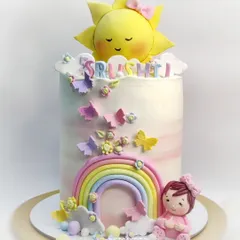 One of my cutest creations, this very tall cake features a sweet sleeping sun, a pastel rainbow, and a little baby girl. It travelled safely to Thane in heavy rains.
