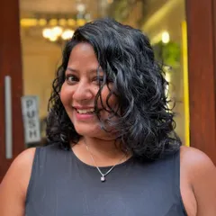 The client's happy face, framed by her new curly bob. It's a fresh, modern, and easy-to-manage style.
