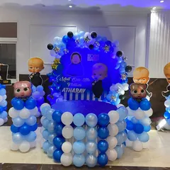 A "Boss Baby" themed first birthday party, perfect for your little leader. This decoration includes a custom circular backdrop, character cutouts, and balloon pillars in shades of blue and white, creating a fun and stylish photo zone.