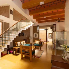 The open-plan living area combines warm yellow oxide flooring with exposed earth block walls and a striking jack arch ceiling, creating a space that is both expansive and inviting.