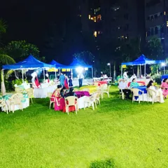 This image shows the seating and food stall area at a large outdoor festival. I arrange canopies for food counters and provide ample seating for guests to relax and eat.