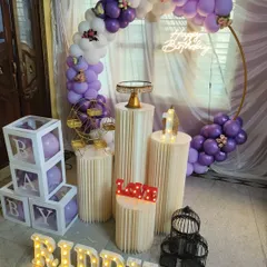 A lovely purple and white balloon ring for a first birthday, accented with delicate butterfly details, a neon sign, and matching balloons in the 'B-A-B-Y' blocks.