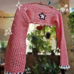 A closer look at our pink mesh bolero crop top. The star patch and ruffled details on the cuffs make this a fun and trendy piece to layer over your favorite top or dress.