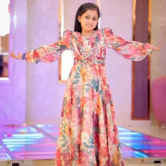 A happy girl in a floral dress, posing on a light-up dance floor at her birthday party.