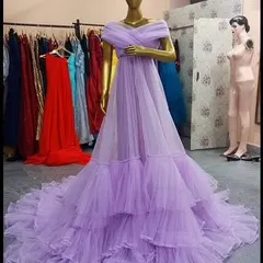 Our lavender ruffled gown is a fairytale dream come true. The soft pastel color and voluminous tiered skirt create a whimsical and romantic look, shown here on a mannequin.