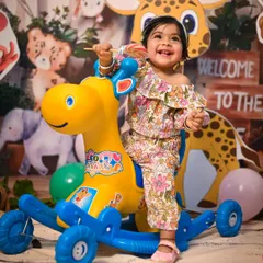 Our Jungle Safari theme includes fun props for kids to play with, like this giraffe rocker. The backdrop features friendly cartoon animals, creating a playful atmosphere for a pre-birthday photoshoot.