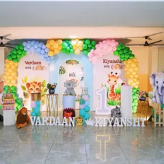 A "Wild One" jungle theme is perfect for celebrating a first birthday, and even better for twins. This double backdrop features cute animal graphics, balloon arches, and separate personalized signs for each child.