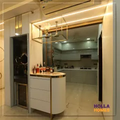 This bespoke bar unit features a curved counter, a suspended glass holder, and warm accent lighting, creating a sophisticated corner for entertaining.