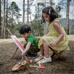 Two young siblings lost in their own creative world, painting together during an outdoor session. I love creating setups that let kids be themselves, resulting in natural and artistic photographs.