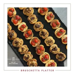 A beautiful Bruschetta Platter, featuring a variety of toppings on crispy toasted bread. It's a simple, elegant, and delicious option for any party, delivered ready to serve.
