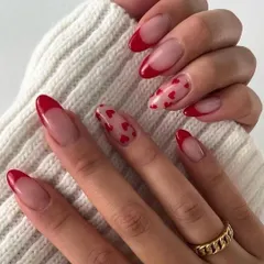Valentine's Day inspiration featuring a classic red French manicure with a playful heart accent nail. It's a romantic and chic design.