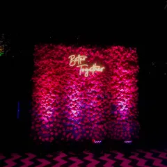 I designed this modern photo booth with a wall made entirely of red roses. The neon sign adds a contemporary touch, creating a popular spot for guests to take memorable pictures during the reception.