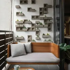 This custom-built wooden swing bench offers a minimalist and sophisticated seating solution. It's paired with a unique wall feature made of concrete planter blocks, blending modern design with natural elements for a truly unique balcony.