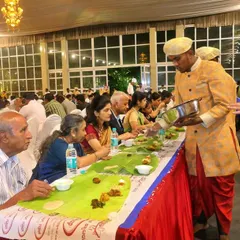 Personal attention is key in my service. Here, one of my senior staff members in traditional attire serves an elderly guest, showing the respect and care we bring to every table.