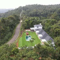 An aerial shot of the Panorama Peaks Cottage in North Coorg, a premium homestay set high up in a coffee plantation, offering complete seclusion and luxury.