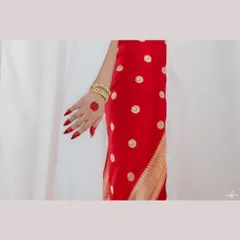 A detail shot of Sonakshi's hand, showing her alta and bangles against her red saree. These small details are an important part of the story of a bride's look.