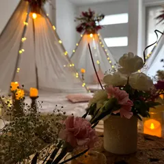 A close up view of the cozy details in our slumber party decor. Soft textures, warm candlelight, and fresh flowers create an inviting space for guests to relax and connect.