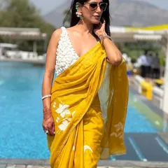 Another look at this stunning hand-painted saree. The combination of the vibrant yellow and the delicate white floral pattern is perfect for summer events. The modern, textured blouse adds a touch of unexpected flair.