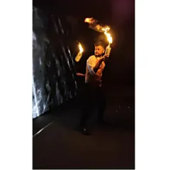 A dramatic shot of a fire flair performance in a dark setting. The contrast of the flames against the night highlights the skill and danger involved, making it a thrilling spectacle for any cocktail party.