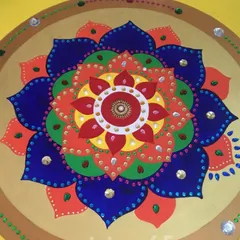 A detailed view of a multi-colored mandala design. We create these calming and spiritual patterns for wall hangings or as part of larger installations, perfect for creating a peaceful atmosphere in homes or yoga studios.