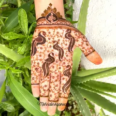 A graceful pattern on the back of the hand featuring stylized bird motifs. The delicate vine work and crowned wristband make this a unique and elegant choice for any occasion.