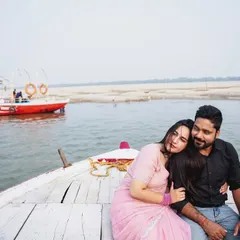 A serene and romantic moment on the Ganges. The couple relaxes at the front of the boat, creating a peaceful portrait against the backdrop of the river.