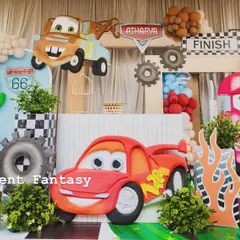 A full stage setup for Atharva's Disney Cars birthday. The scene is packed with characters like Lightning McQueen and Mater, along with Route 66 signs, cacti, and gas station props.