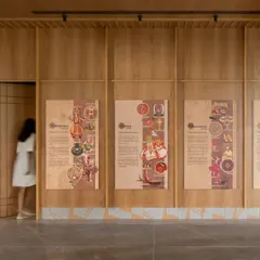 The auditorium lobby features wood-paneled walls with beautifully designed graphic panels that narrate the rich cultural history of India. A concealed door seamlessly integrates into the paneling, showcasing our attention to detail.