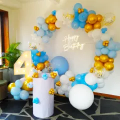A bright and cheerful birthday setup. This circular balloon arch in shades of blue, white, and gold, paired with a "Happy Birthday" neon sign and a "4" marquee number, creates a fun and inviting party atmosphere.