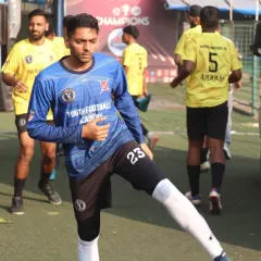 A player in our blue goalkeeper kit warms up before a crucial match, stretching and preparing to defend our goal.