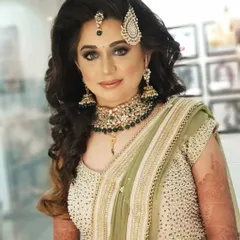 Your reception look should be just as stunning as your wedding day makeup. For this bride, we chose a glamorous smokey eye and a soft nude lip to match her elegant green saree. Her hair was styled in voluminous waves, creating a modern and chic look for her evening celebration.