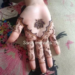 A unique design on the palm featuring a lotus and rose motif. The pattern extends down the fingers with delicate leafy vines, creating a very pretty and modern look.