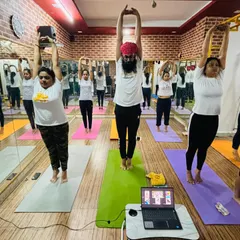 Students practicing a standing side bend together, seamlessly blending our online and offline communities.