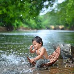 The pure delight on a child's face as he splashes in the river during an outdoor adventure photoshoot.