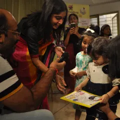 A little one proudly shows off her copy of our 'Color & Learn' book during our Musical Book Tour. These events are designed to be fun, interactive, and educational for the whole family.