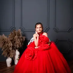 A full-length view of the red floral gown. The volume and design of this dress are perfect for creating dramatic and memorable portraits for your child.