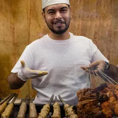 A member of our team serving up freshly grilled kebabs. We are proud to carry on the tradition of hospitality that Bademiya is known for.