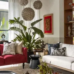 For the living room at The Collector's Retreat, I wanted to create a space that felt both curated and deeply comfortable. The bold red sofa adds a burst of energy, while the layered textures, art pieces from the client's collection, and oversized plants come together to tell a rich, personal story. This is a room designed for lively conversations and quiet afternoons.