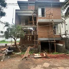 The Divyadarshan residence in its early construction phase. This image shows the skeleton of the house, with scaffolding in place as the mud block walls are being built.