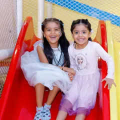 Double the slides, double the fun. These two friends are all smiles as they get ready to race down our bright and safe slides.